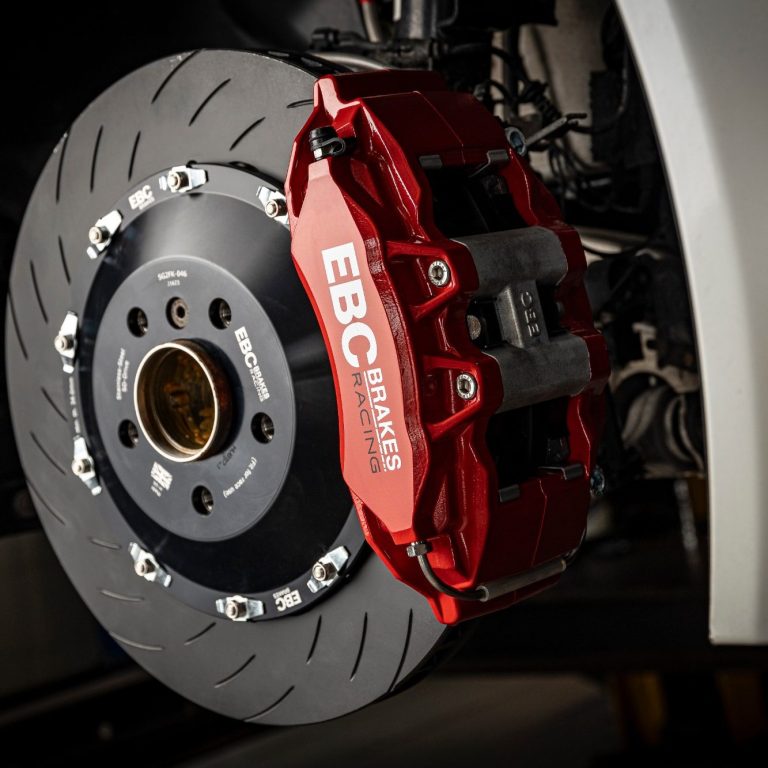 Rote Bremssattel mit Bremsscheibe, Teil einer Hochleistungsbremsanlage.